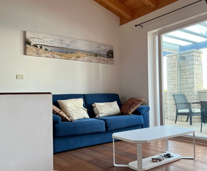 Soggiorno con divano e accesso alla terrazza coperta