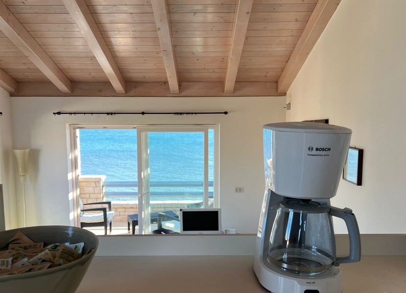 Vista dalla cucina sulla zona giorno, sulla terrazza e sul mare