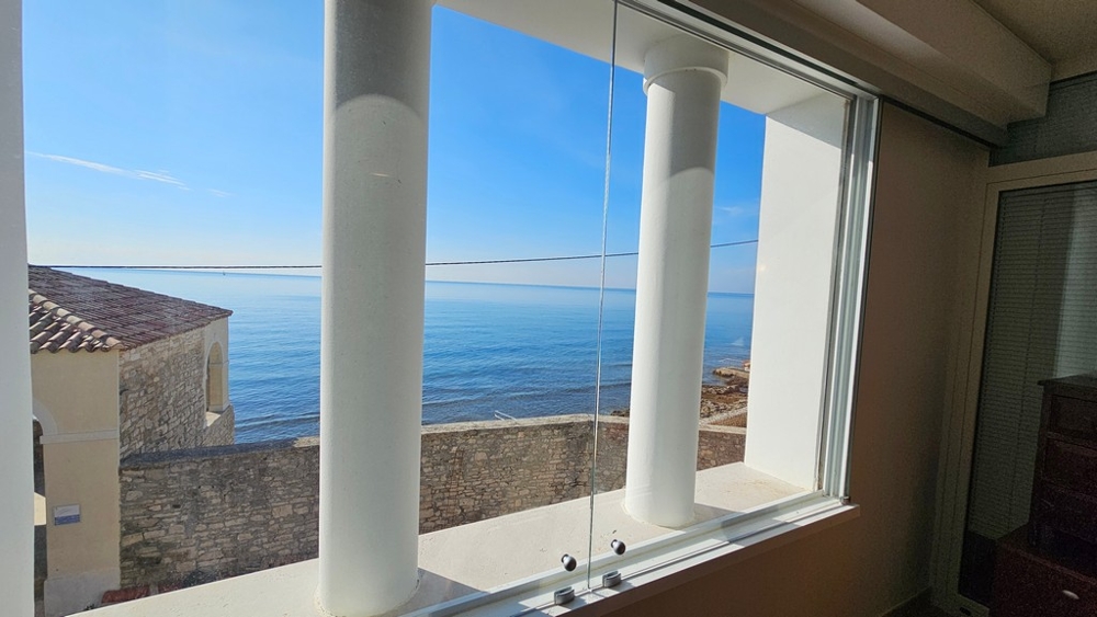 Vista dalla finestra d'angolo sul muro del lungomare fino al mare