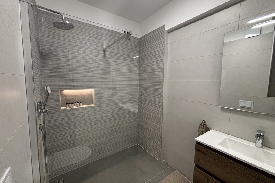 Bagno con doccia a filo pavimento e lavabo