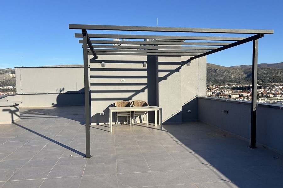 Ampia terrazza sul tetto con pergola e vista sulla città