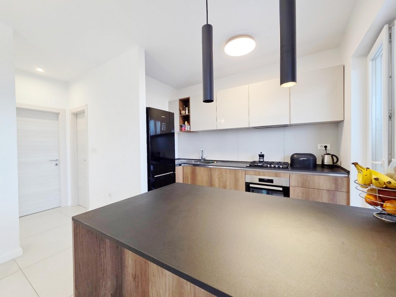 Cucina con isola e lampade a sospensione nere