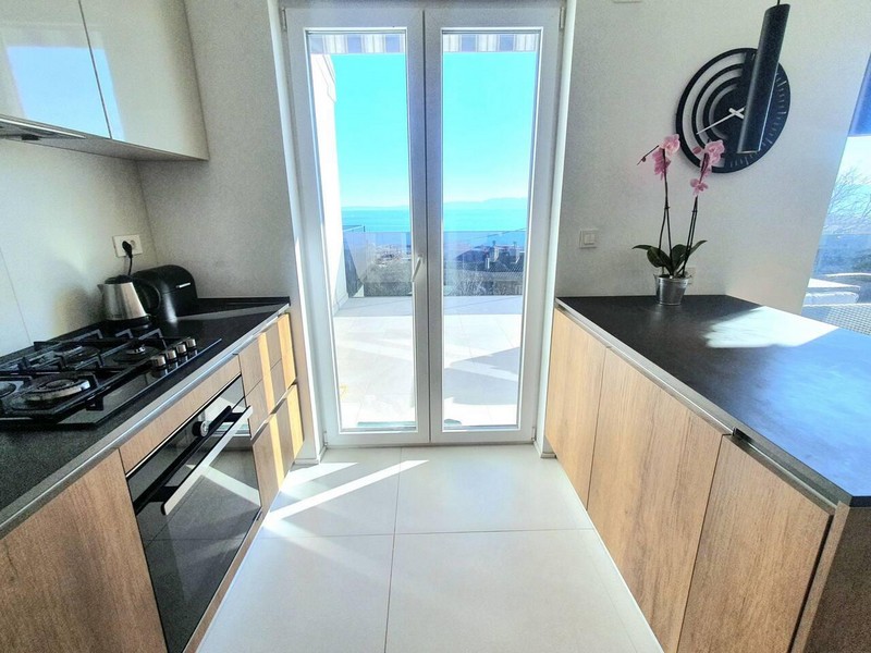 Cucina con orchidea e porta della terrazza verso il mare