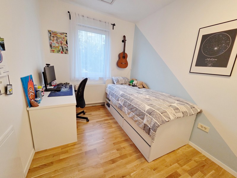 Camera per ragazzi con scrivania, letto e chitarra alla parete
