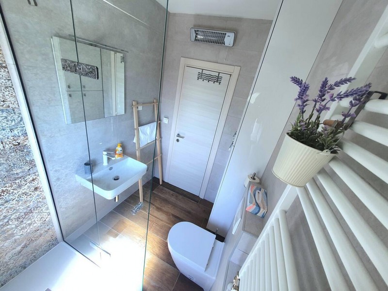 Bagno con doccia in vetro e termoarredo