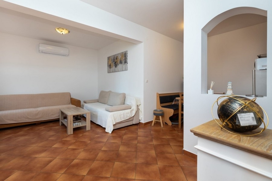 Zona giorno dell'appartamento con sedute e passaggio alla cucina