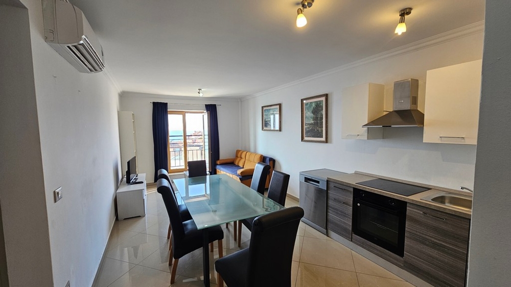 Soggiorno luminoso con cucina aperta, zona pranzo e vista sul mare