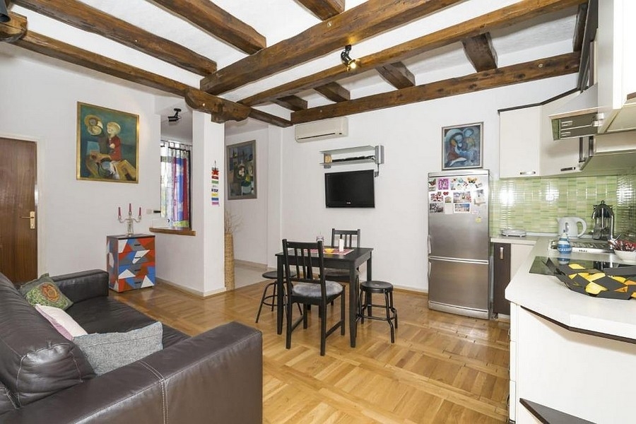 Zona giorno con cucina e zona pranzo e soffitto a travi in legno