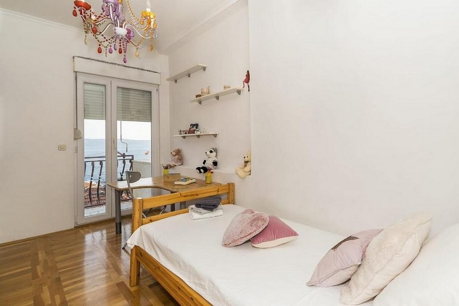 Cameretta con letto e accesso al balcone con vista mare