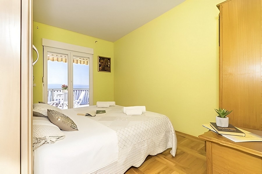 Camera da letto con due letti e balcone con vista mare