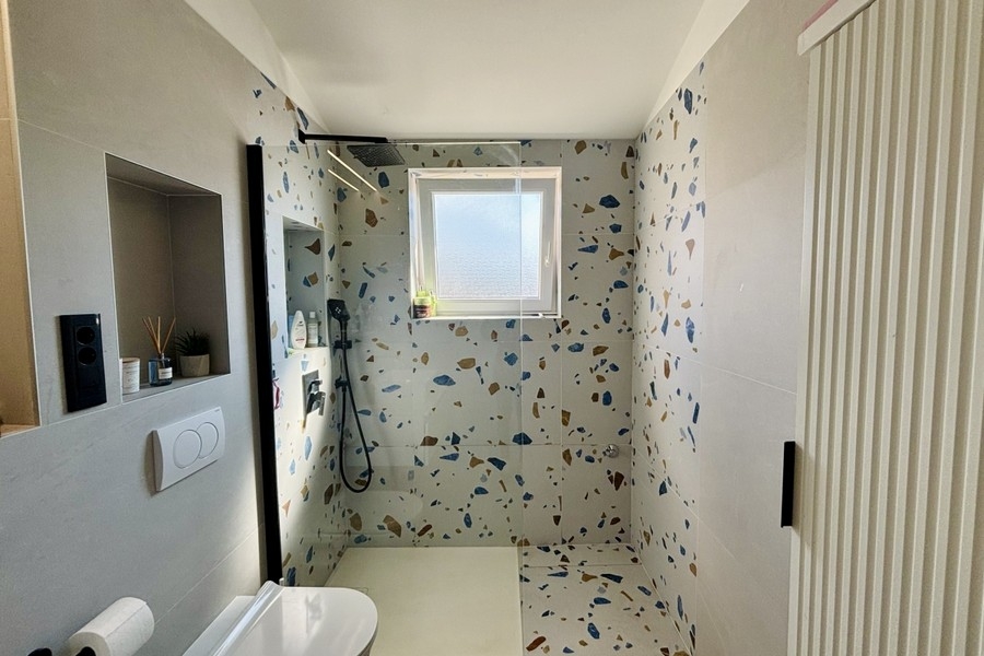 Bagno moderno con doccia a filo pavimento e finestra