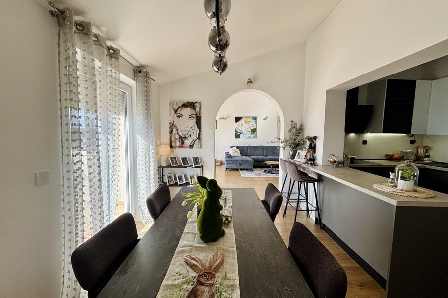 Zona pranzo aperta con accesso alla cucina e molta luce naturale