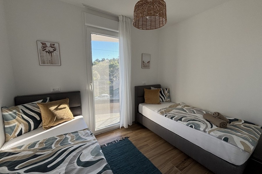 Camera da letto con due letti singoli e accesso al balcone