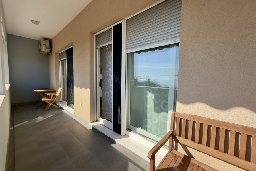 Loggia con panca in legno e tapparelle alle finestre
