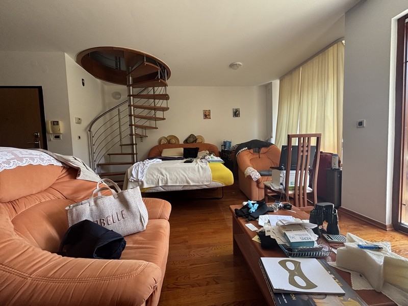 Zona giorno con divani e scala a chiocciola verso il piano superiore