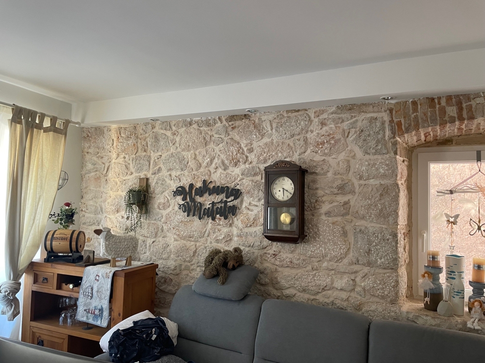 Soggiorno con parete in pietra naturale e decorazioni