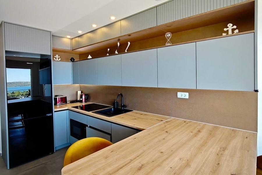 Cucina a vista con bancone e sgabelli da bar