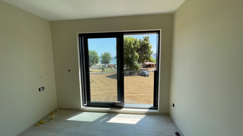 Stanza con porta della terrazza e vista sul verde