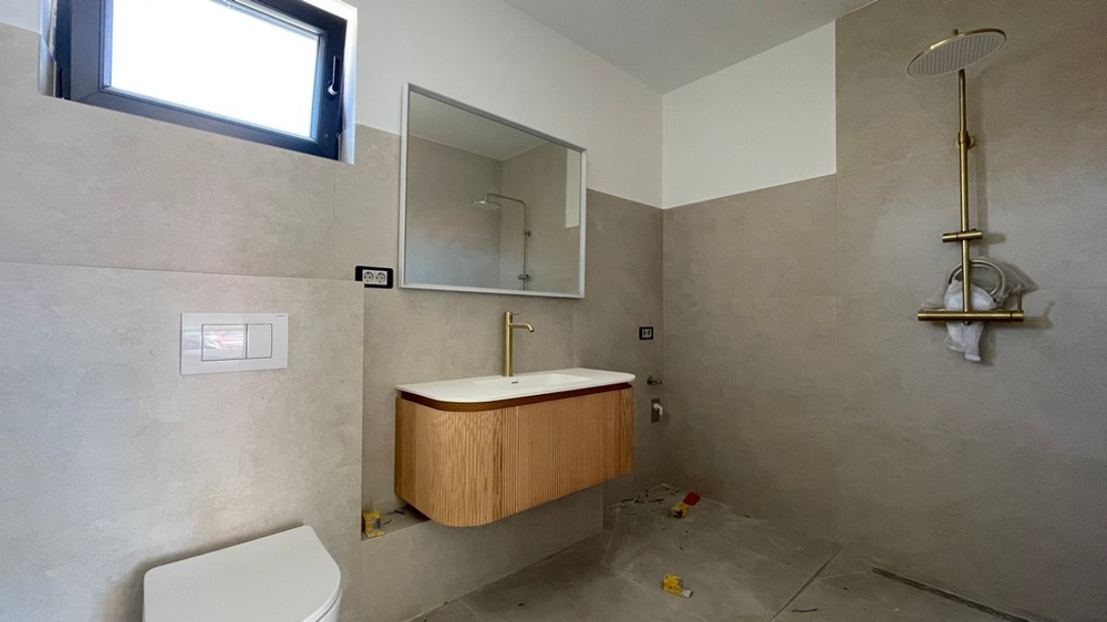 Bagno moderno con doccia a pioggia e lavabo in legno