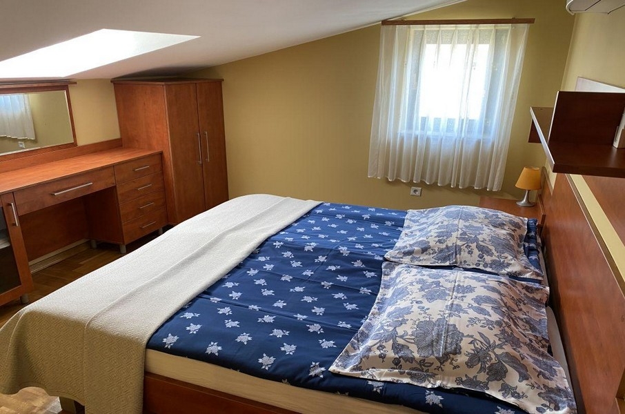 Camera da letto con letto matrimoniale e lucernario in un appartamento a Krk