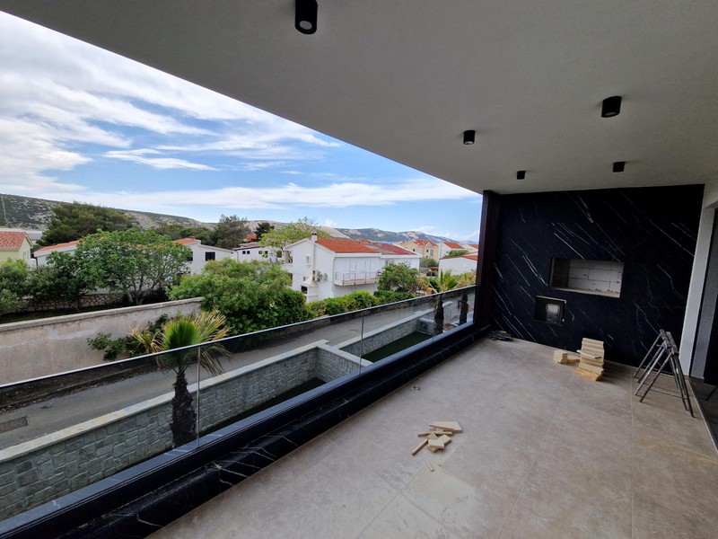 Balcone coperto con parapetto in vetro e vista sulle case vicine