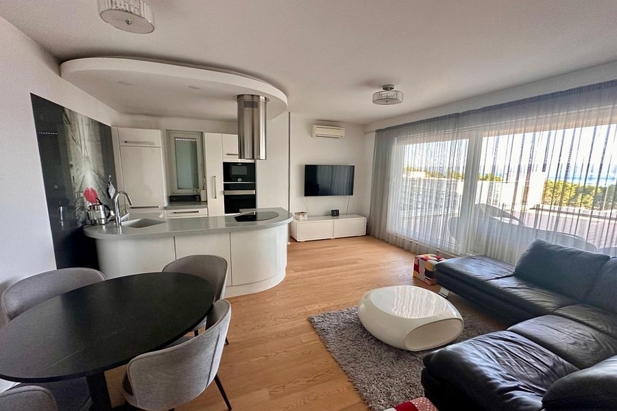 Zona giorno con cucina a vista e grandi vetrate