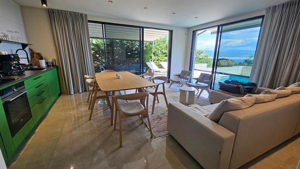 Cucina aperta con tavolo da pranzo e vista mare