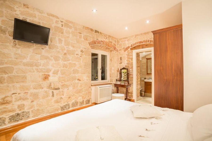 Camera da letto con parete in pietra naturale e letto matrimoniale