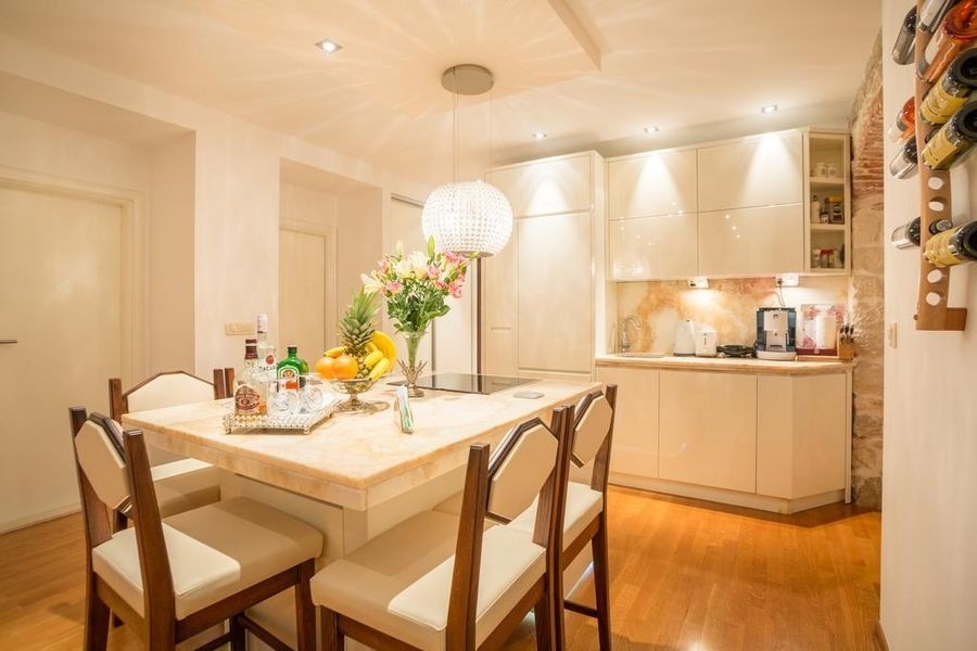 Zona pranzo con tavolo e cucina aperta