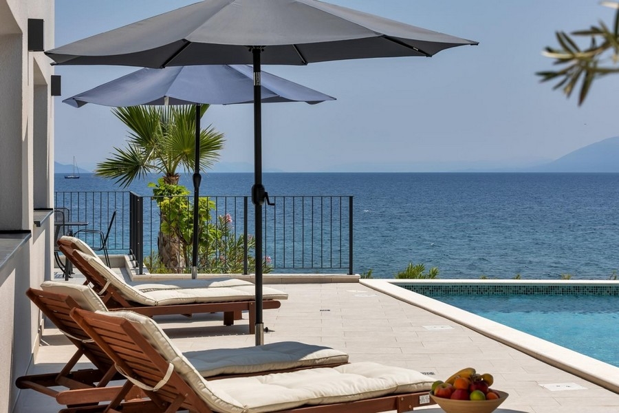 Terrazza con lettini e vista mare presso la piscina