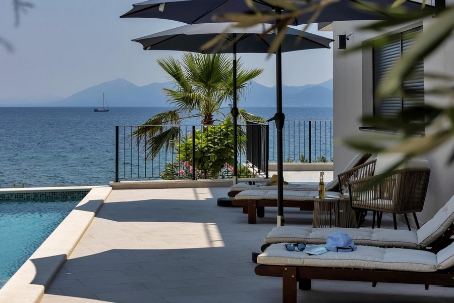 Terrazza della piscina con palma e vista sul mare