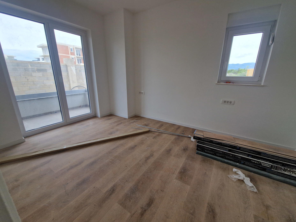 Stanza con pavimento in legno e accesso alla terrazza