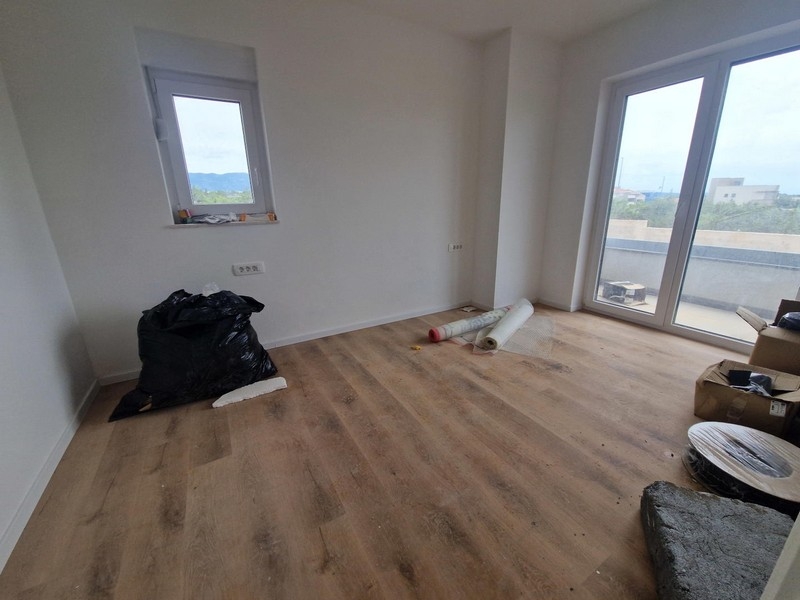 Stanza luminosa con parquet e porta della terrazza