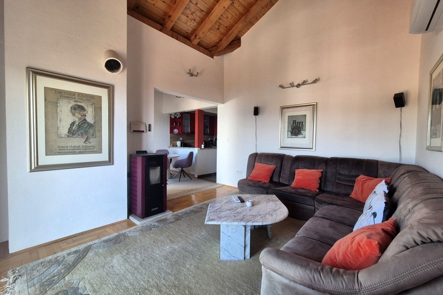 Zona giorno luminosa con alto soffitto in legno