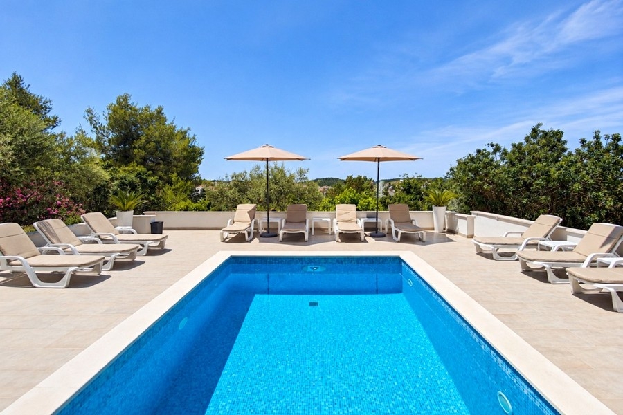 Piscina comune con lettini e vista mare