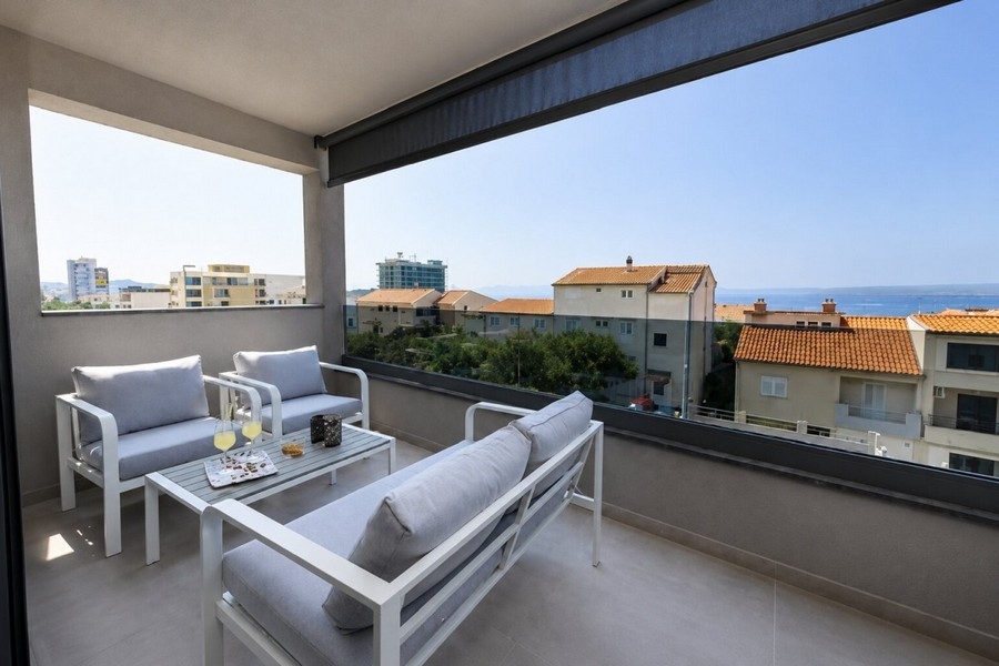 Terrazza coperta con mobili lounge e vista mare a Makarska