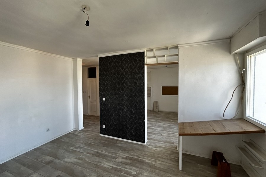 Zona giorno con pavimento in laminato e finestra a tutta altezza