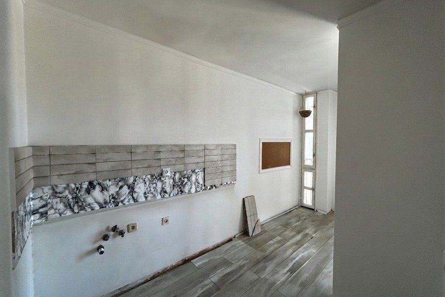 Zona cottura con parete piastrellata e finestra