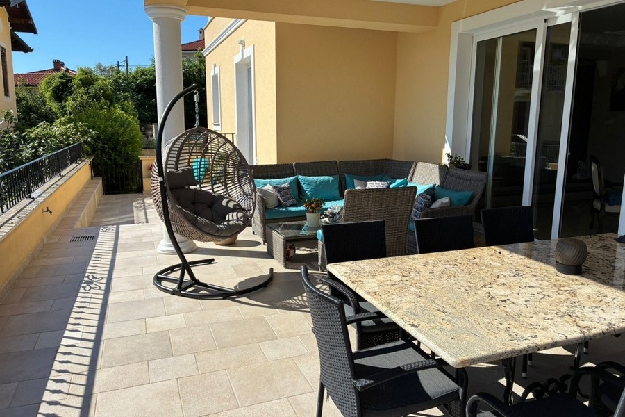 Terrazza coperta con angolo salotto e tavolo da pranzo