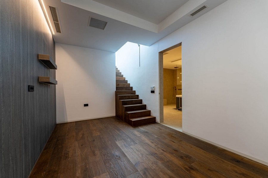 Ingresso con scala in legno e bagno al piano seminterrato