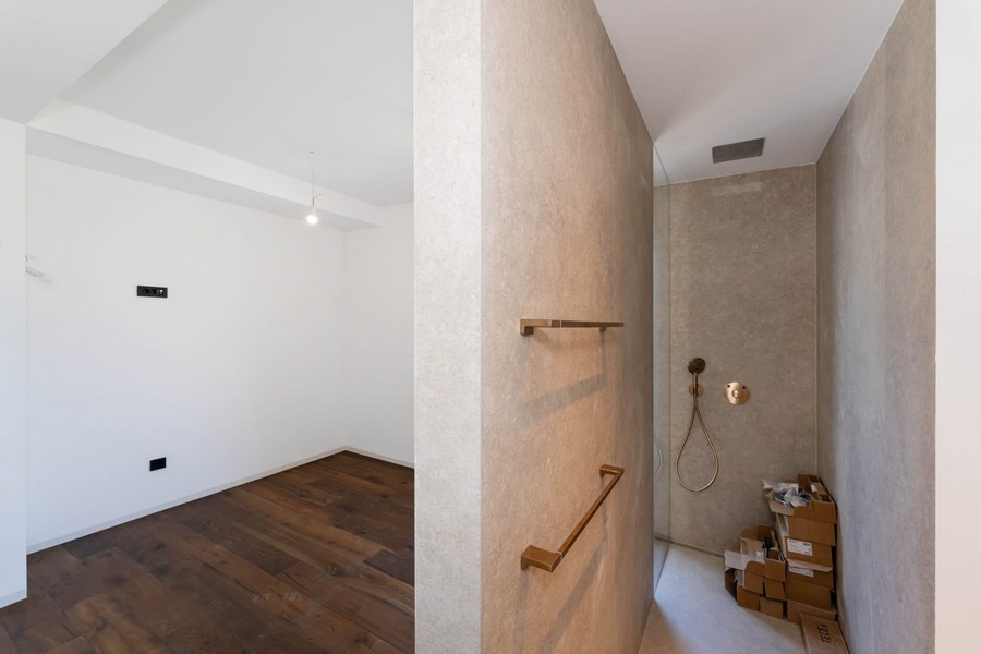 Stanza con pavimento in legno e doccia walk-in