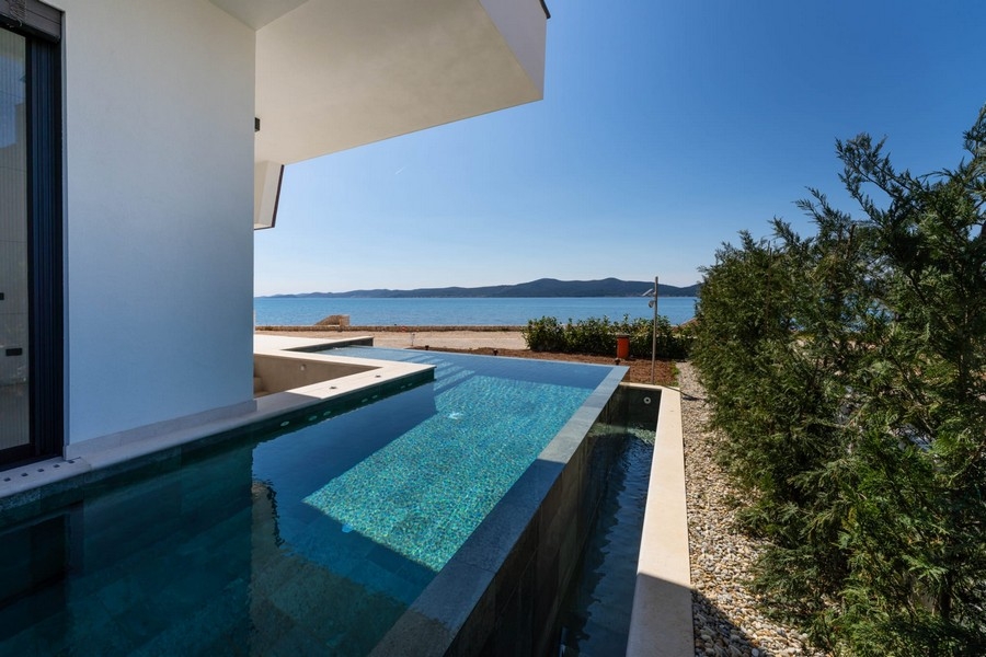 Piscina dell'appartamento con piantumazione e mare sullo sfondo