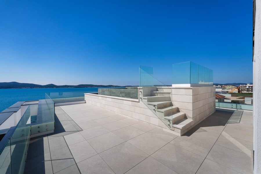 Terrazza sul tetto con scala e parapetto in vetro sul mare