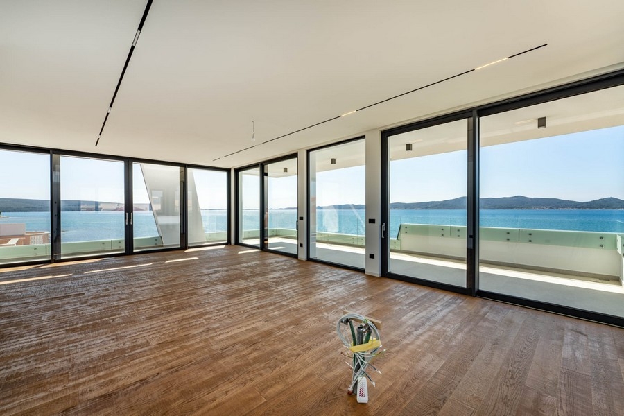 Zona giorno aperta con parquet e vista mare