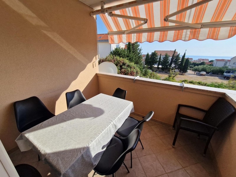 Loggia con tavolo e sedie sotto la tenda da sole