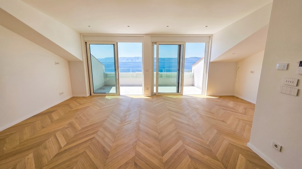 Zona giorno con parquet a spina di pesce e accesso alla terrazza