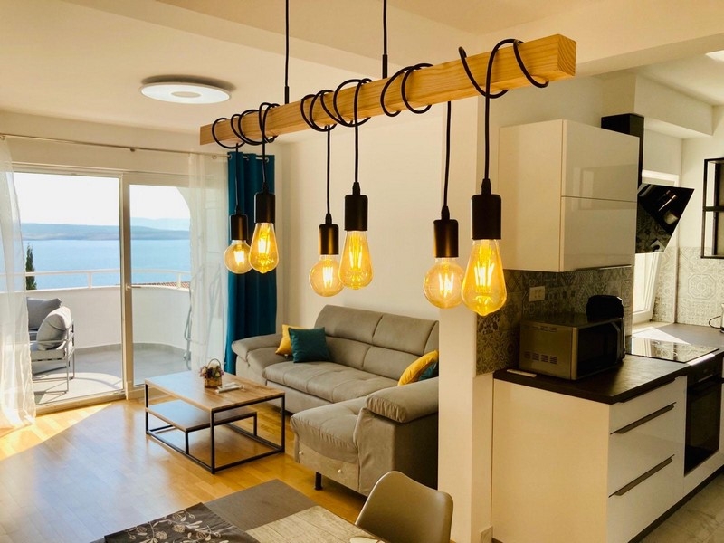 Zona giorno con cucina aperta e accesso al balcone