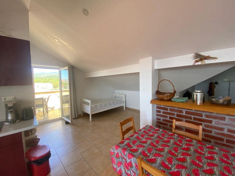 Zona giorno con soffitto spiovente e accesso alla terrazza