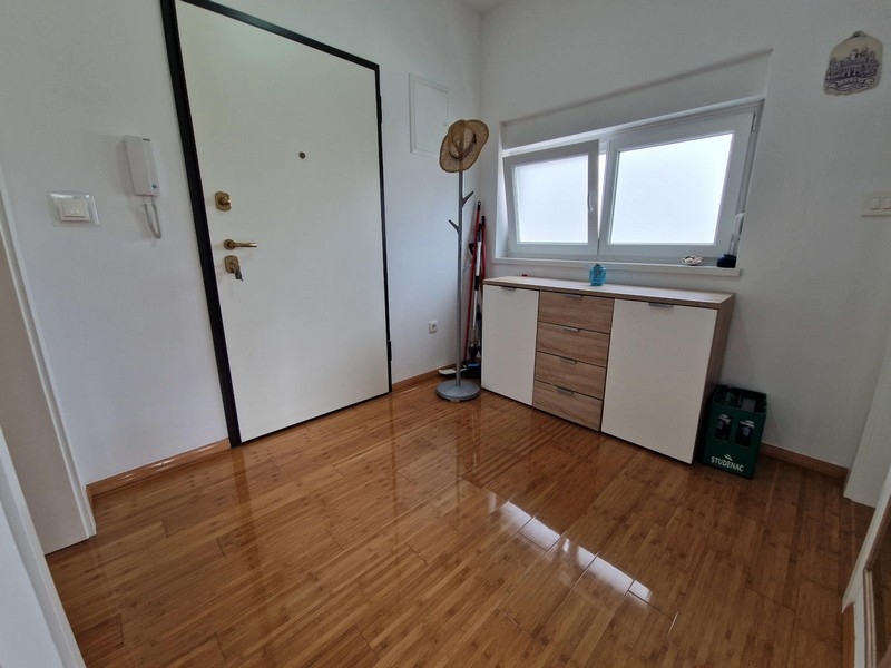Corridoio con porta d'ingresso e credenza
