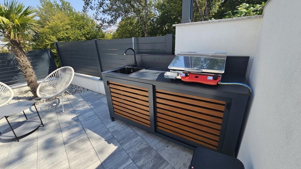 Cucina estiva con zona barbecue nel giardino dell'appartamento a Malinska